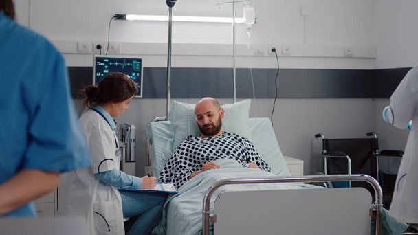 Médicos examinando homem doente verificando sintoma de doença - Foto, Imagem