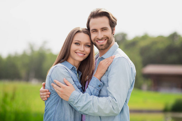 Photo portriat young couple smiling walking in green park wearing blue denim jackets summer evening - Zdjęcie, obraz