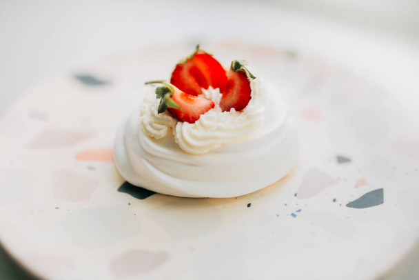 Sweet dessert, Pavlov's cake with butter cream and strawberries. Soft focus background, a place for text . - Valokuva, kuva