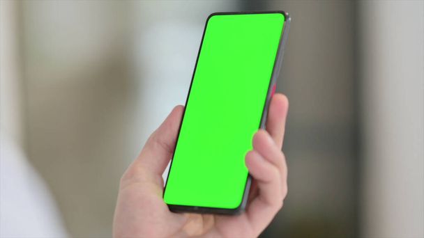 Mann hält Smartphone mit grünem Chroma-Bildschirm - Foto, Bild