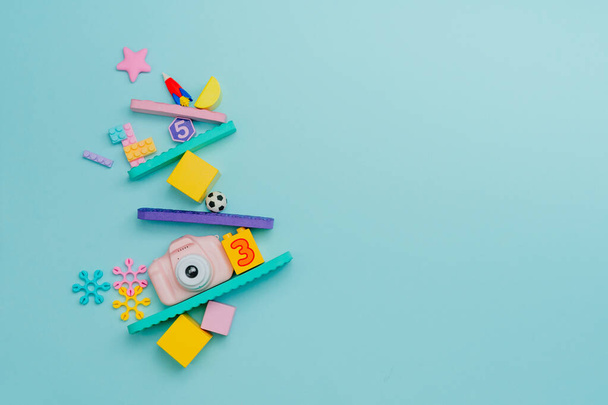 Equilibrio minimalista hecho por juguetes para niños sobre fondo azul con espacio en blanco para texto. Vista superior, plano. - Foto, Imagen