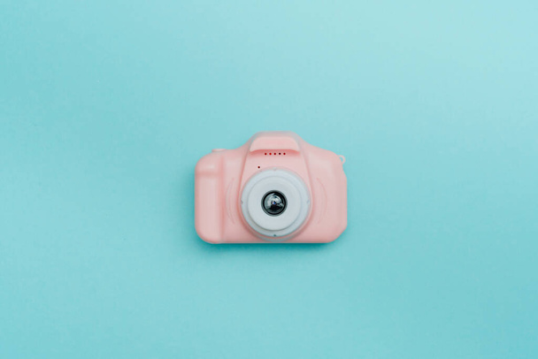 Plastikspielzeug-Fotokamera auf blauem Hintergrund mit Leerraum für Text. Draufsicht, flache Lage. - Foto, Bild
