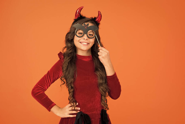 happy halloween. kid wear devil horns. child with funny party attribute. teen girl has long curly hair and wear dress for holiday celebration. autumn season holidays. childhood leisure. copy space - Фото, зображення
