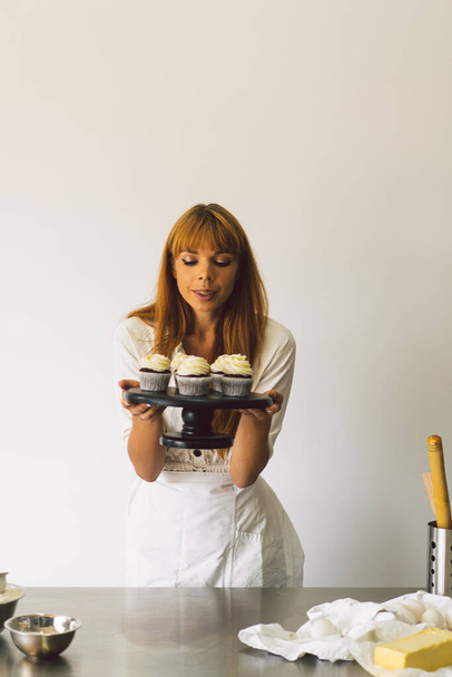 Дівчина-кондитер готує кекси. Концептуальні інгредієнти для приготування борошняних виробів або десерту
 - Фото, зображення