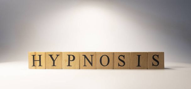 The word hypnosis was created from wooden cubes. education and work. - Photo, Image