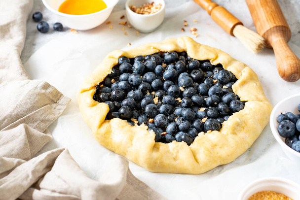 The process of making a French galette or pie with blueberries. Ingredients for summer baking on culinary background - Φωτογραφία, εικόνα