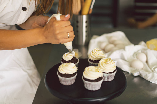 Suikerbakkersmeisje bereidt een cupcake. Concept ingrediënten voor het koken van meelproducten of dessert - Foto, afbeelding