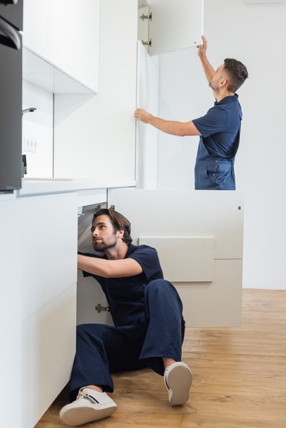 klusjesmannen maken meubels in de moderne keuken - Foto, afbeelding