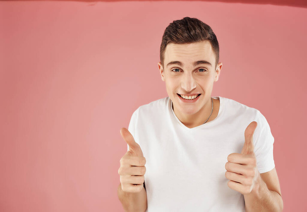 emotional man gesturing with his hands in a white t-shirt pink background close-up - Photo, Image