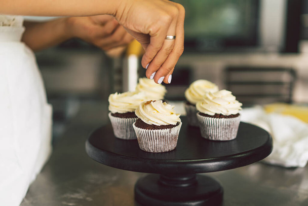 Confectioner girl is preparing a cupcakes. Concept ingredients for cooking flour products or dessert - Foto, Bild