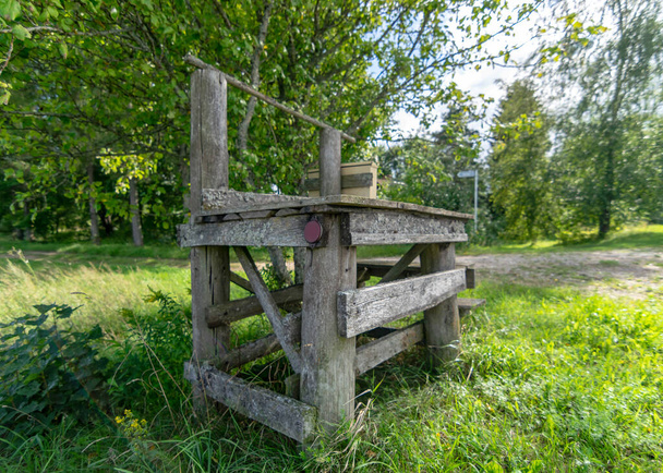 kesämaisema vanha puinen tikkuja, vanha puurakenne, historiallinen maito kannu keräyspaikka - Valokuva, kuva