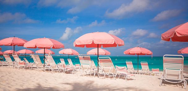 Парадоксальный вид на пустынный песчаный пляж с зонтиками и стульями
 - Фото, изображение