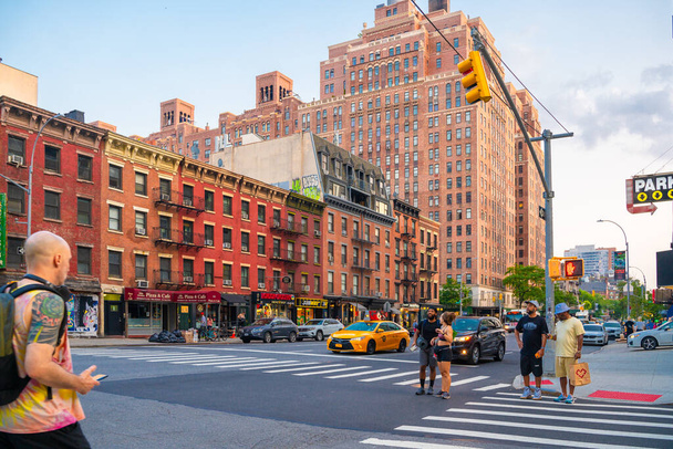 New York City, New York, USA - July 15, 2021:  Street scene from Chelsea neighborhood in Manhattan of intersection with people, buildings and cars. - Foto, Bild