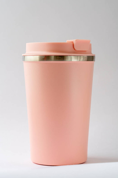 Růžový termopohár nebo termoska hrnek na čaj nebo kávu na bílém pozadí. Horký nápoj - Fotografie, Obrázek