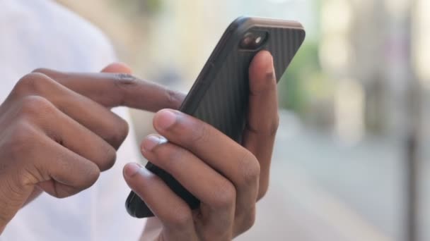 Nahaufnahme der Hände eines Afrikaners mit Smartphone  - Filmmaterial, Video