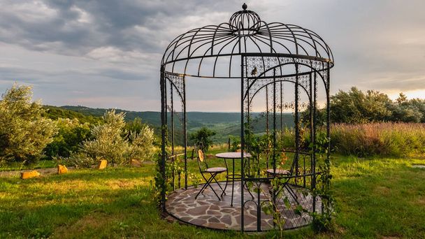 A metal gazebo with view on the hills during sunset. - Photo, Image