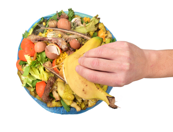 ręka pokazująca banana do recyklingu organiczne na białym tle - Zdjęcie, obraz