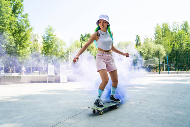 skaters with colored smoke bombs. Professional skateboarders having fun at the skate park - Foto, immagini