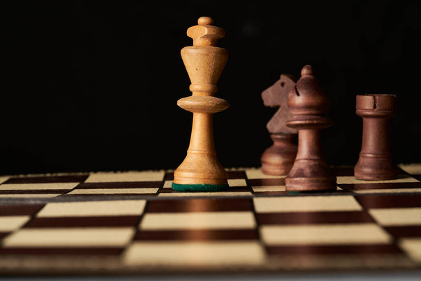 Schachspiel mit weißem König umgeben von schwarzen Figuren, Schachmatt - Foto, Bild