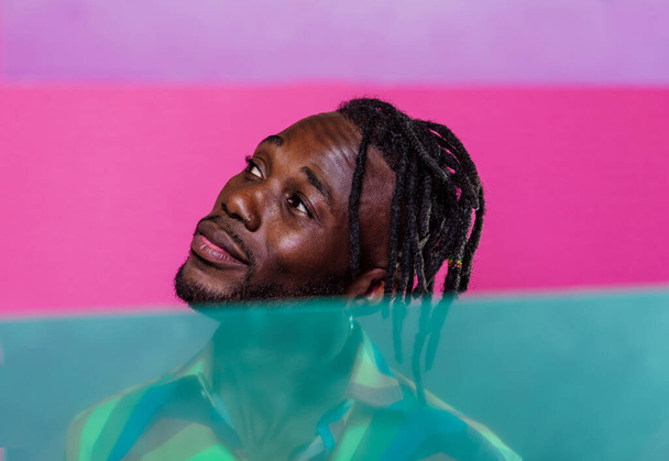 Artistic portrait with gel lights. Handsome man posing on colored backgrounds - Foto, Imagen