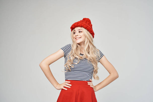 blond in modieuze kleding Red Hat poseren Studio - Foto, afbeelding