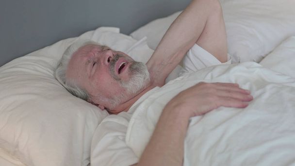 ベッドで首の痛みを持つ排気シニア老人 - 写真・画像