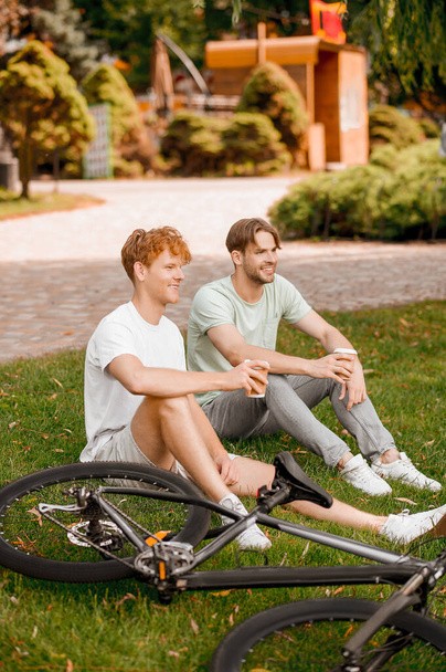 Két sportos barát pihen a szabadtéri kerékpáros edzés után. - Fotó, kép