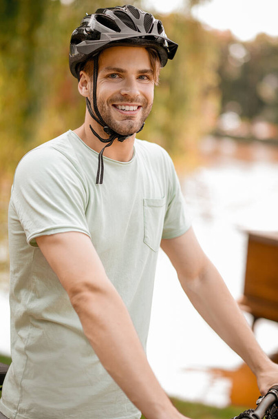 Joyous male athlete wearing protective headgear outdoors - Fotografie, Obrázek