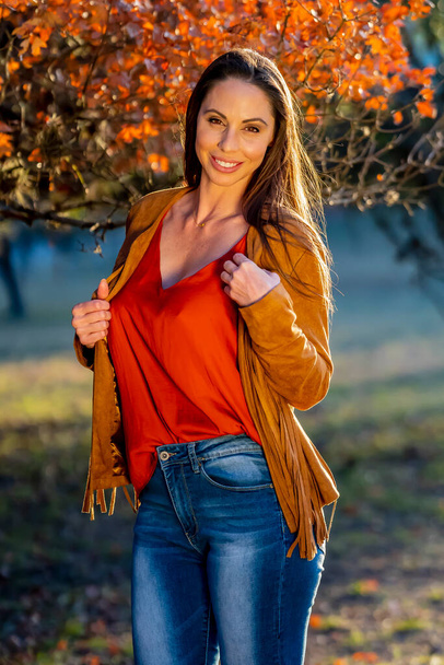 A gorgeous brunette model poses outdoors while enjoying the autumn weather - Fotoğraf, Görsel