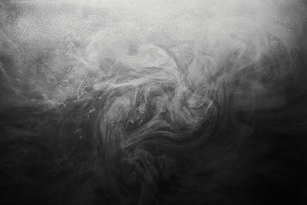 Abstract dark paint in water background. White smoke cloud motion on black, acrylic ink swirl splashes - Фото, зображення
