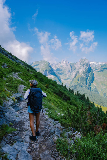 Een vrouw met een rugzak staat op de top van een berg, Het meisje reist naar prachtige plaatsen, Het bereiken van het doel, bergrug bij Saxer Luecke, Kreuzberge in Alpstein Appenzell Innerrhoden Zwitserland - Foto, afbeelding