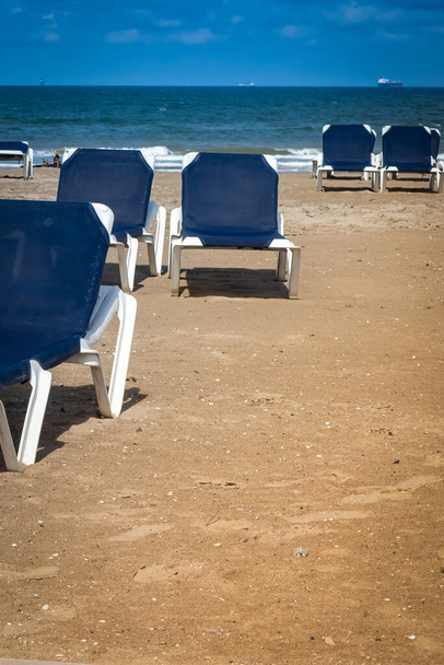 L'Aia, Paesi Bassi, spiaggia di Scheveningen sotto il vento freddo e sedie lunghe vuote blu - Foto, immagini