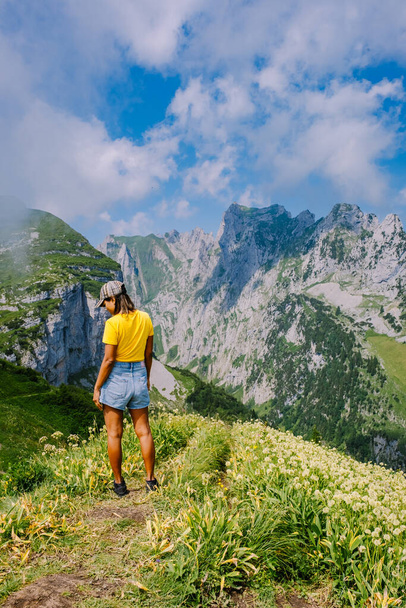 Una mujer con una mochila se encuentra en la cima de una montaña, La chica viaja a lugares hermosos, Alcanzando la meta, cresta de montaña en Saxer Luecke, Kreuzberge en Alpstein Appenzell Innerrhoden Suiza - Foto, Imagen