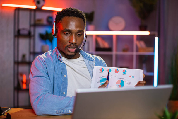 Μαύρος άνδρας με ακουστικά που χρησιμοποιεί φορητό υπολογιστή για τηλεδιάσκεψη - Φωτογραφία, εικόνα