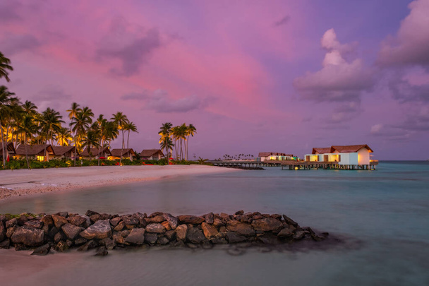 Palmy na tropickém pobřeží při západu slunce. Křižovatka Maledivy, hotel Hard Rock, červen2021. Obrázek dlouhé expozice - Fotografie, Obrázek