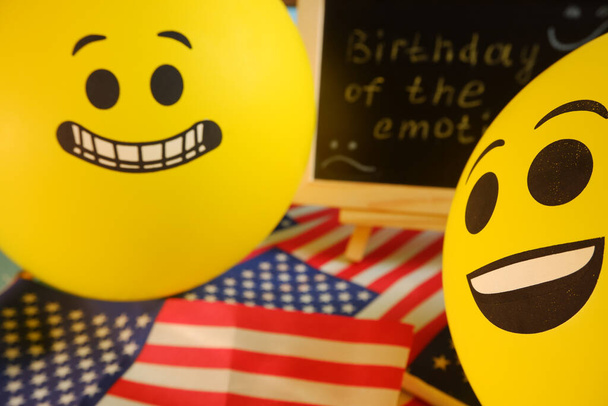 Globos emoji amarillos en el fondo del tablero con la inscripción del evento y banderas americanas. - Foto, Imagen