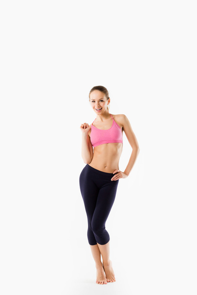Young beautiful woman posing in a gym outfit. - 写真・画像