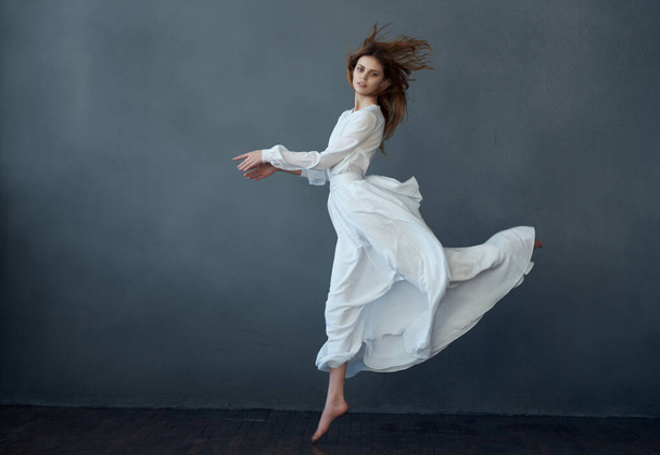 pretty woman dancing in white dress studio isolated background fashion - Фото, зображення