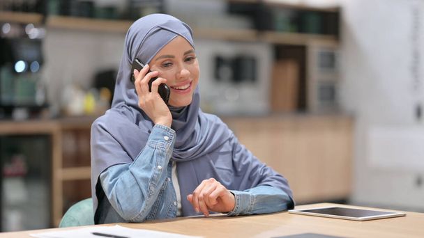 Arab Woman Talking on Phone at Work - Foto, afbeelding