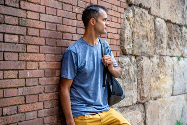 Nuori latino turisti mies seinää vasten kaupungissa - Valokuva, kuva