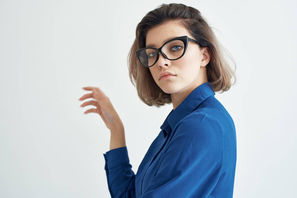 Frau in blauem Hemd trägt Brille Mode elegantes Posen - Foto, Bild