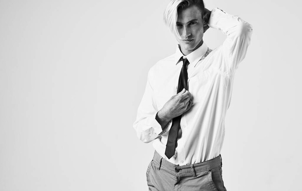 Beyaz gömlekli, kravatlı, şık saç stili, kendine güveni olan siyah ve beyaz arka planlı bir adam. - Fotoğraf, Görsel
