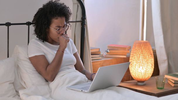 Junge Afrikanerin mit Laptop hustet zu Hause - Foto, Bild