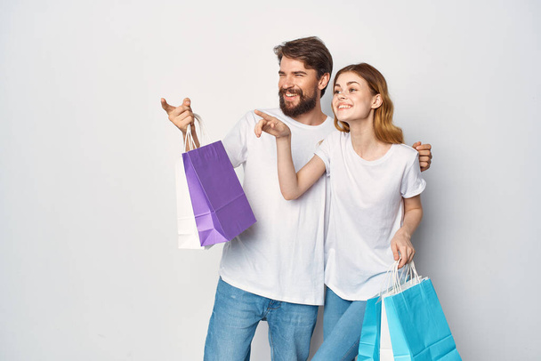 giovane coppia in t-shirt bianche con borse in mano shopping divertimento - Foto, immagini