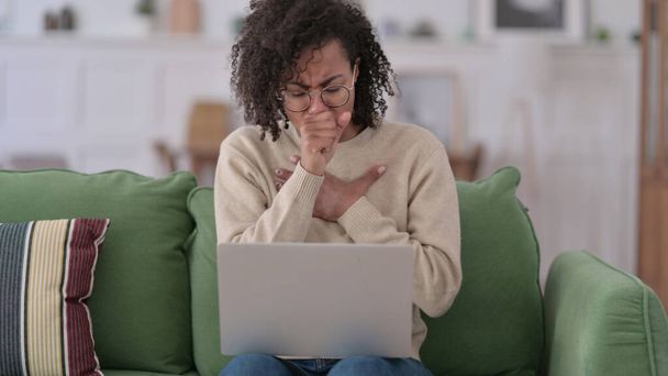 Young African Woman with Laptop Coughing at Home - Foto, imagen