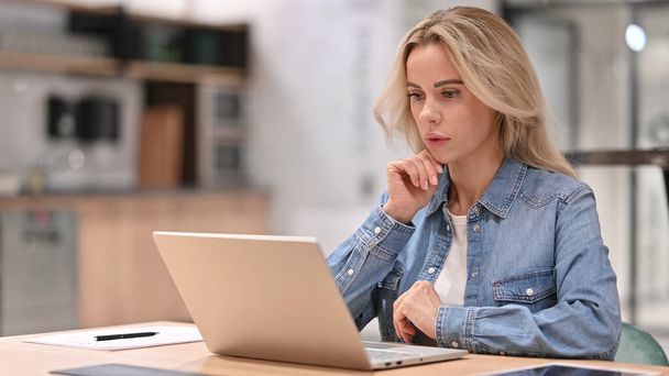 Mujer joven casual con el pensamiento del ordenador portátil en el trabajo - Foto, imagen