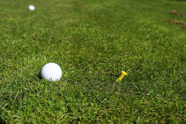 Golf ball on green grass background - Фото, изображение