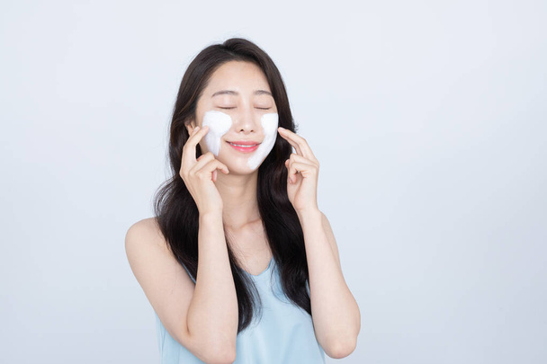 summer skin care, beautiful Asian woman with facial pack on cheek - Photo, image