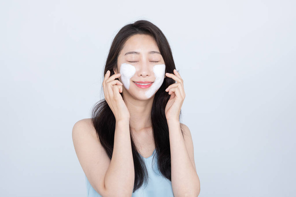 summer skin care, beautiful Asian woman with facial pack on cheek - Фото, изображение