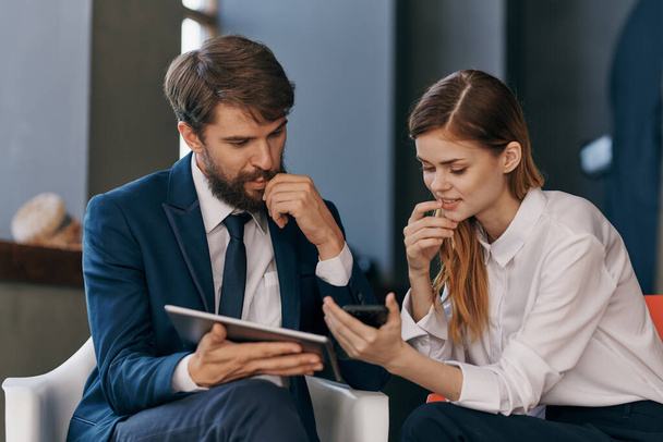 uomo e donna in giacca e cravatta guardando l'ufficio tecnologia tablet - Foto, immagini